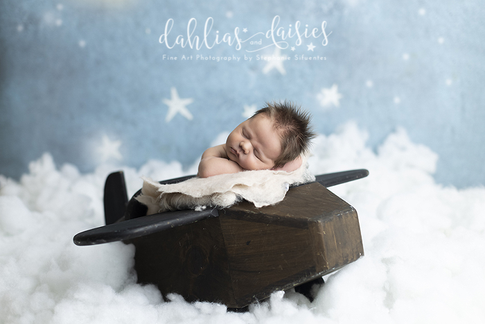 Newborn boy on wooden airplane
