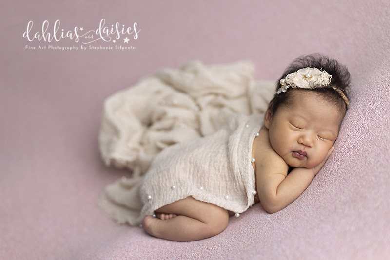 Newborn girl on pink fabric