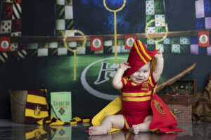 Baby boy plays with quidditch robe Harry Potter cake smash