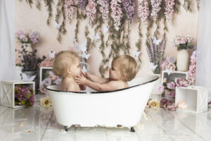 Twin babies splash in the tub at their cake smash