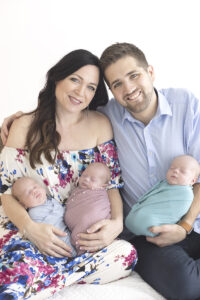 Parents hold newborn triplets