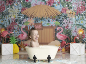12 month old boy laughs in tub at his cake smash