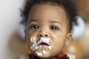 Close up of baby boys icing covered face