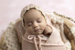Newborn girl wrapped in pink at her newborn photoshoot