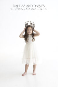Young girl holds crown on her head