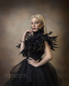 Woman looks at camera while wearing black feathered collar and tulle skirt