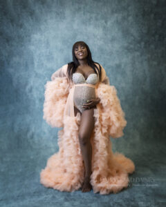Pregnant woman poses with peach robe at maternity photography session