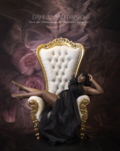 Pregnant woman sits on throne at maternity photography session