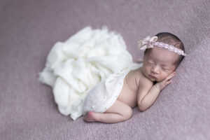 Newborn girl on pink cloth