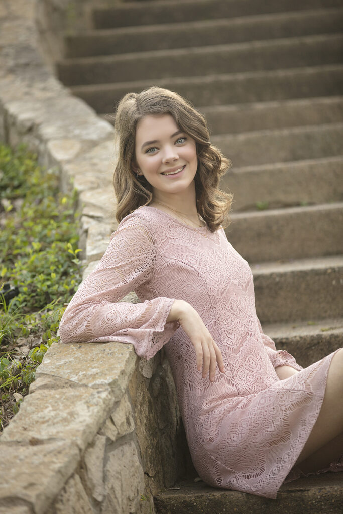 Girl sits on stairs in Davis Parker senior pictures
