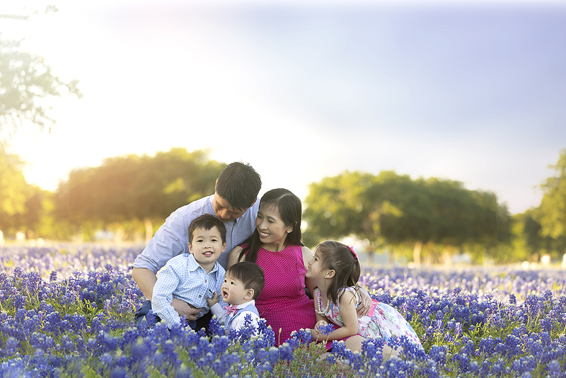 Family sits in the bluebonnets