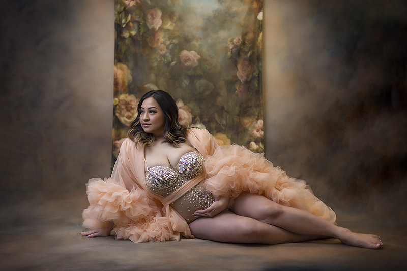 Pregnant woman poses on floor at maternity photoshoot