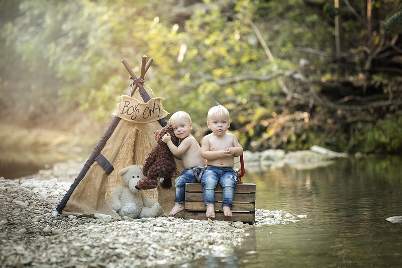 Boys playing with teddy bears in a creek