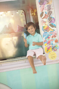 Boy sits on ice cream truck window