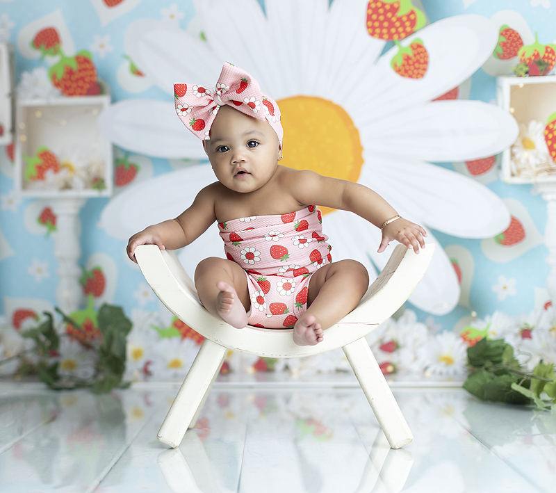 Adorable bay girl wears strawberry themed outfit at Dallas cake smash photo session