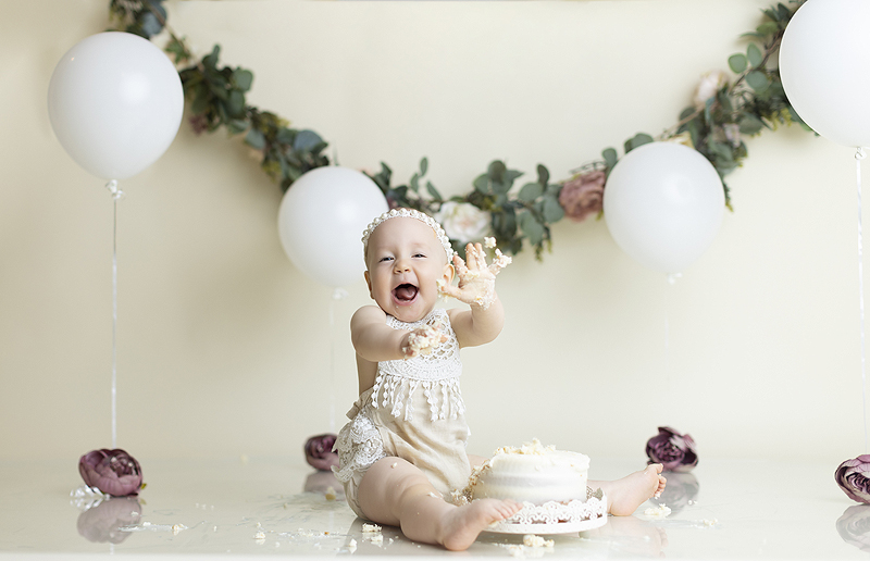 Baby throws cake during floral cake smash photography session