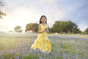 Girls picks flowers in bluebonnet field