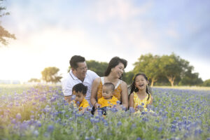 Family laughs in bluebonnet field