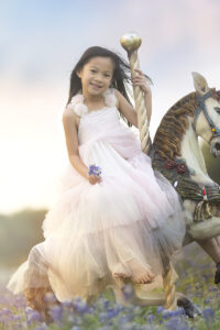 Girls smiles while sitting in carousel horse