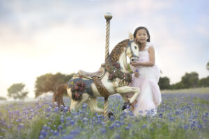 Girl poses with horse in bluebonnet field