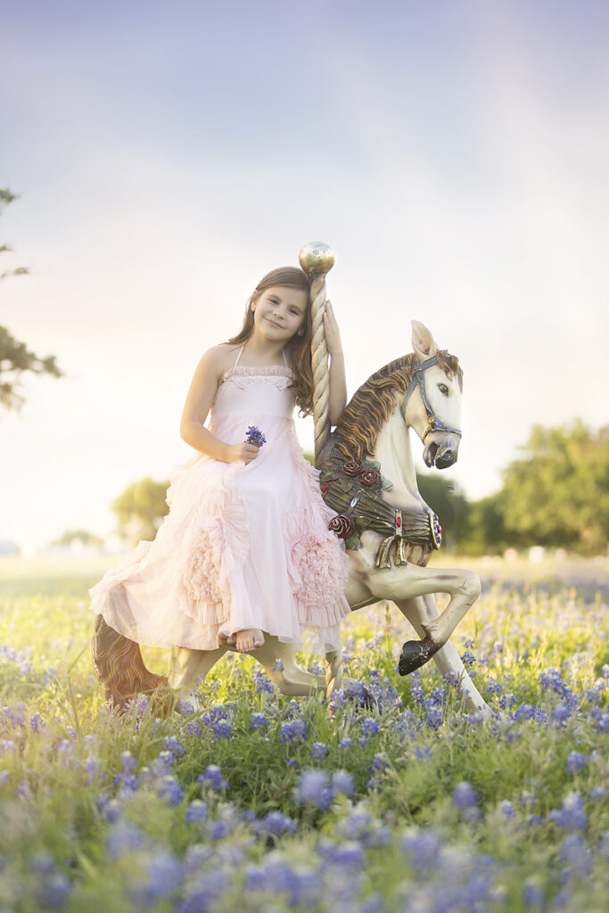 Girl sits on horse in bluebonnet field