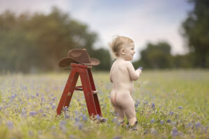 Toddler boy with cowboy hat in flower field