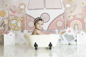 Baby plays in mini tub at her cake smash photo session