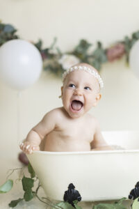 Baby girl laughs in mini tub