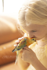 Girl kisses her baby bird