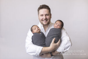 Proud father holds newborn boys