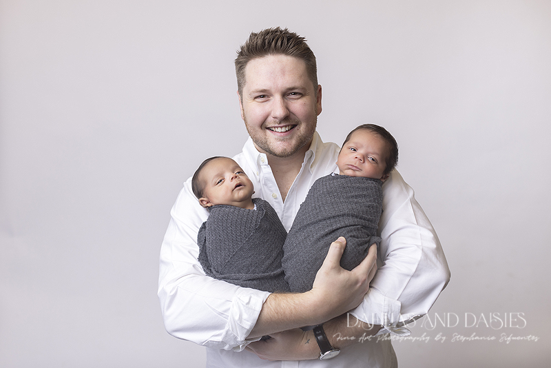 Proud father holds newborn boys