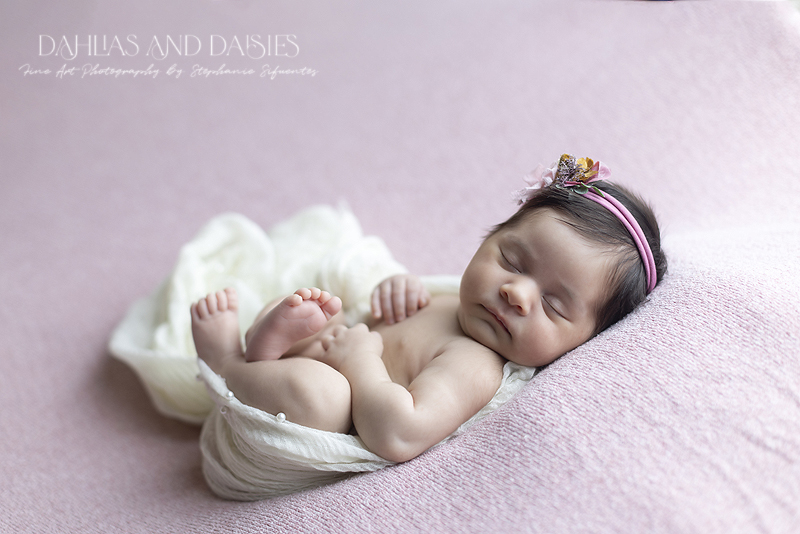 Newborn girl on pink Fabric
