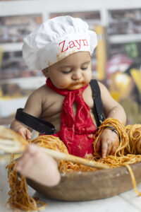 Baby dressed as chef at cake smash