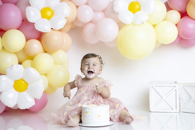 Smiling 1 year old girl at cake smash