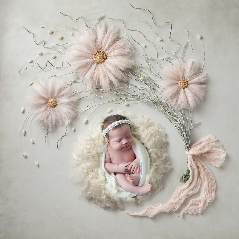 Newborn girl sleeps among flowers