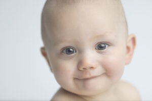 Clean picture of a 6 month old baby face against white background.