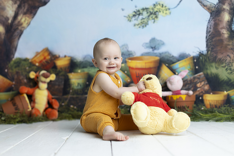 6 month old boy plays with Pooh doll