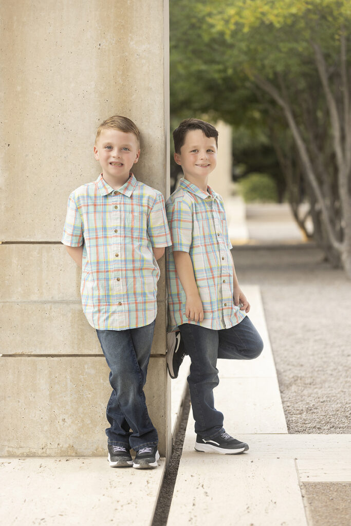 Twins boys pose on column together