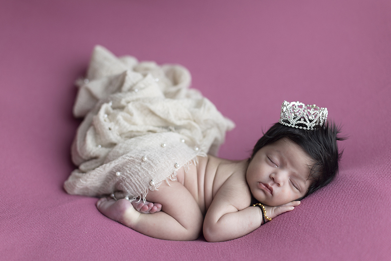Newborn girl wears princess crown