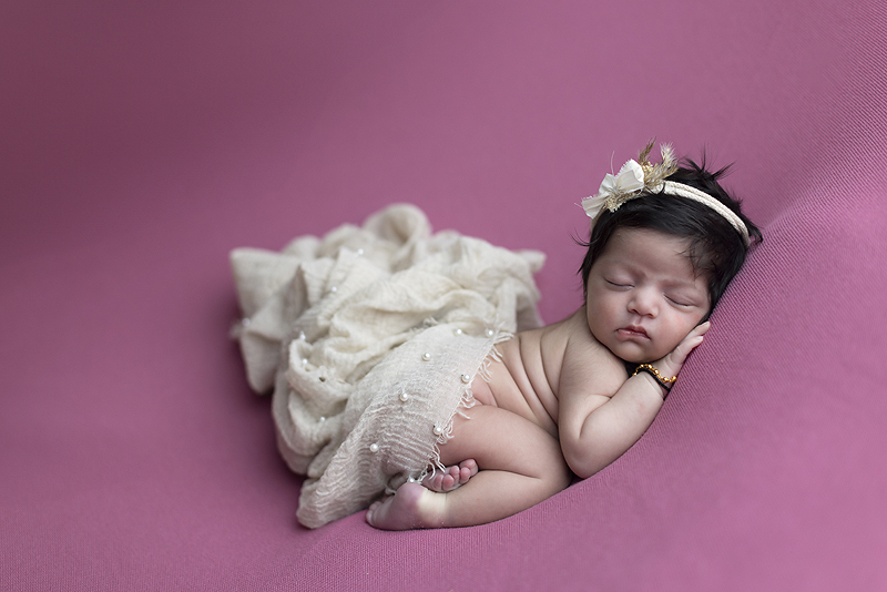 Newborn girl on pink blankets at newborn photo session