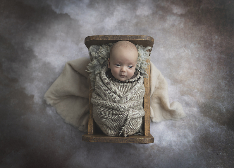 Newborn boy wrapped in basket