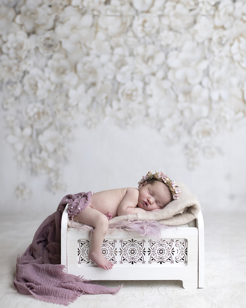 Newborn girl on white bed