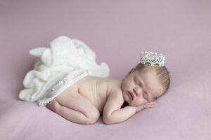 Newborn girl sleeps on pink fabric