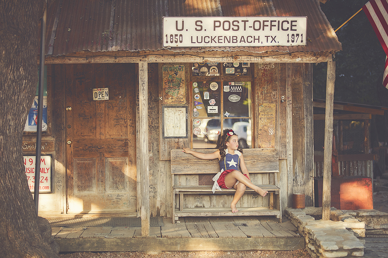 Girl wearing a patriotic jumper sits at old fashioned post office