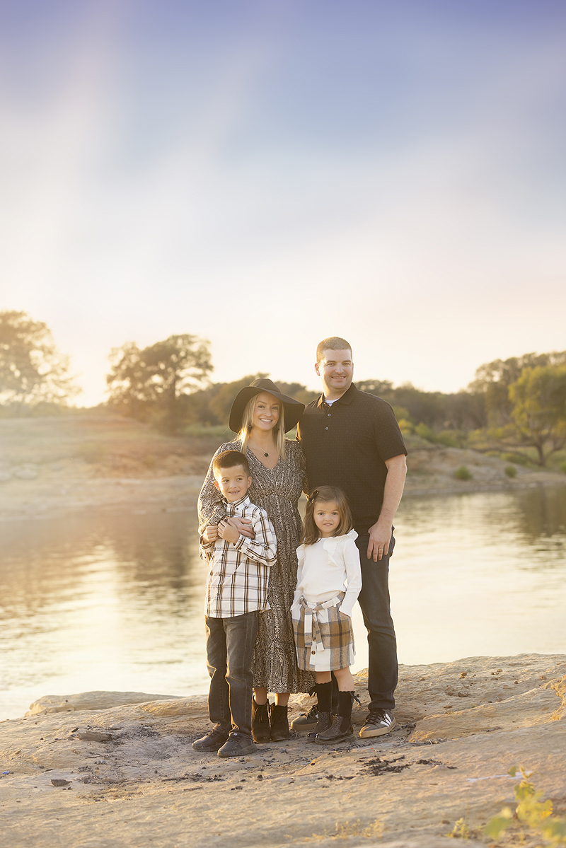 Family poses together at the lake